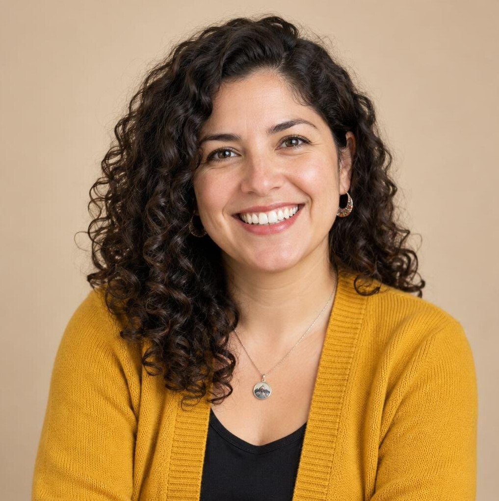 Portrait of a cheerful Chilean woman community coordinator in her thirties with curly dark hair